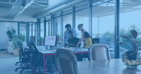 Discussing four colleagues in business casual leaning over desk at open office, with laptop monitor