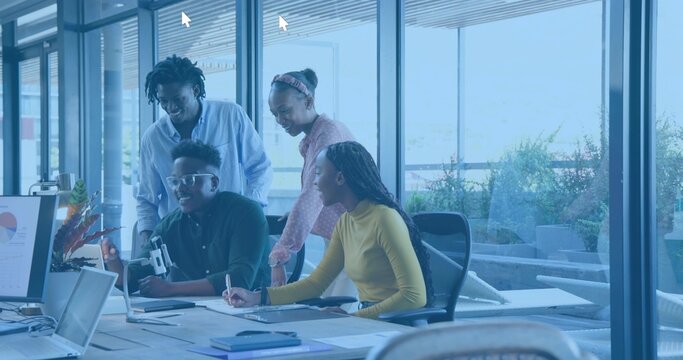 Collaborating team in smart-casual attire studying laptop and chart at glass office with tripod