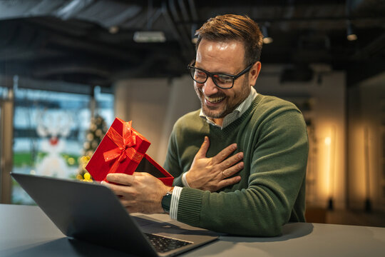 Man smiling receiving christmas gift during video call