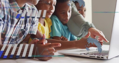 Leaning teacher in plaid guiding five kids at table, pointing at laptop trackpad, blue graphics