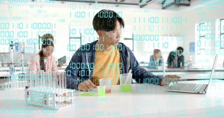 Mixing teen Asian student at school lab bench, with open laptop, goggles and binary overlay