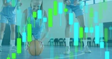 Crouching midadult player holding basketball on gym court, light blue jerseys, candlestick charts