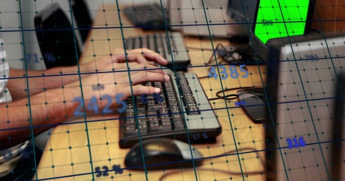 Typing man in checkered shirt at desk, using keyboard, wired mouse and smartphone under data grid
