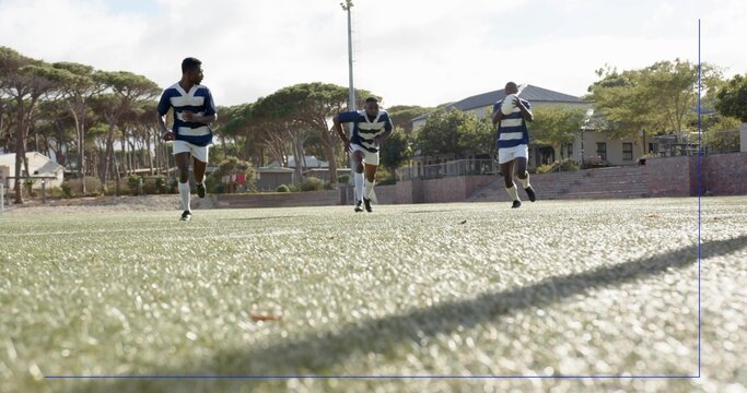 Sprinting three rugby players running on artificial turf at park, in striped jerseys and cleats