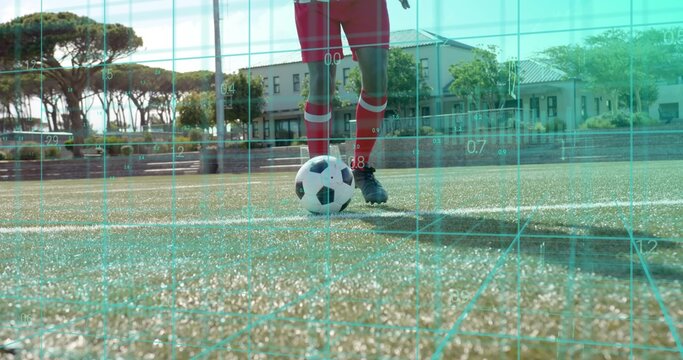 Standing soccer player wearing red kit, controlling ball on marked pitch with cyan grid overlay - Powered by Adobe