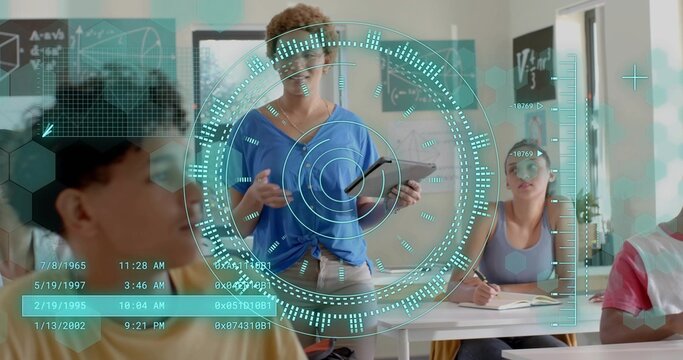 Presenting teacher in blue top holding tablet at classroom front, showing holographic HUD