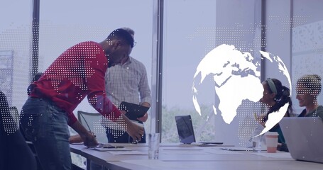 Leaning man in red sweater reading papers in conference room with laptops globe overlay, copy space