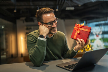 Man receiving gift during video call at home office