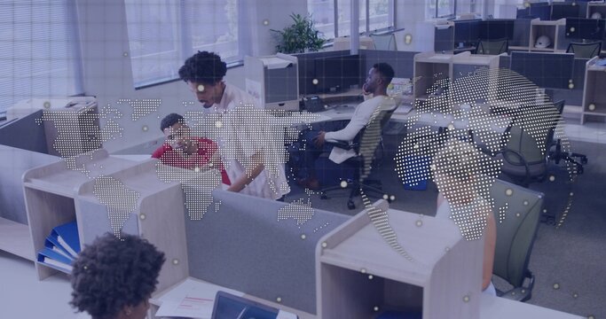 Leaning coworker in light shirt helping seated colleague over partition in office, dotted map - Powered by Adobe