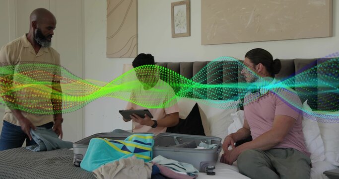 Packing three men arranging casual clothes on bed at home, with open suitcase, tablet, digital wave