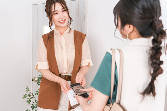 A woman and a store clerk making barcode payment, QR code payment, electronic money, smartphone payment, and cashless payment.
