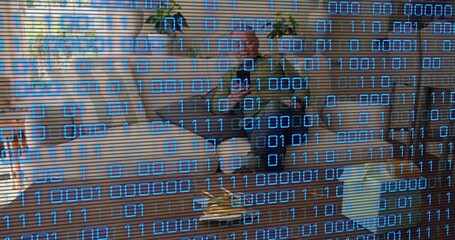 Mature man reaching for object near sofa, rising to retrieve it while tech binary digits overlaying