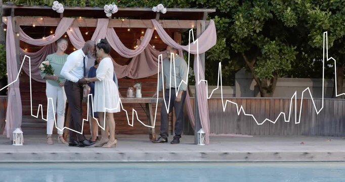 Officiant speaking and holding hands, guiding couple exchanging rings, celebrating wedding by pool