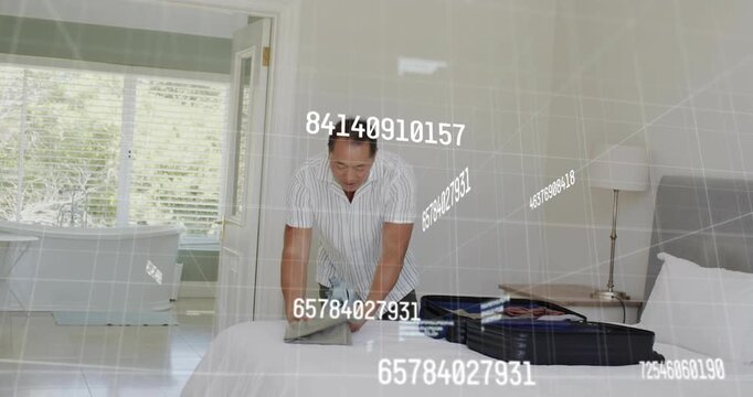 Mature man folding and packing suitcase for travel, floating numerical AR graphics tracking items