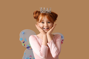 Surprised cute girl in fairy costume on brown background