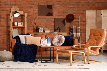 Interior of living room with leather sofa, armchair, shelving unit and coffee table