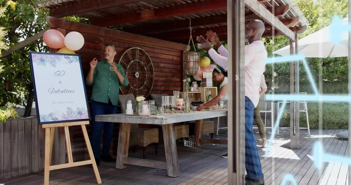 Four hosts arriving at pergola, arranging 60th sign for party, attaching balloons, adjusting table