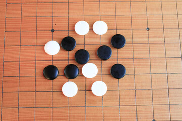 GO Japanese traditional game playing black and white stone pieces on wooden grid board. Strategy and concentrate game  