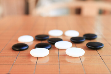GO Japanese traditional game playing black and white stone pieces on wooden grid board. Strategy and concentrate game  