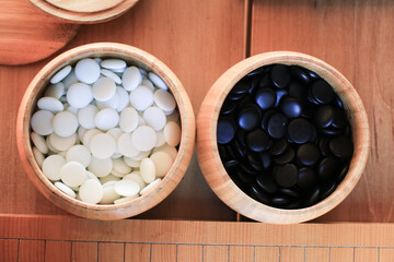 GO Japanese traditional game playing black and white stone pieces on wooden grid board. Strategy and concentrate game  
