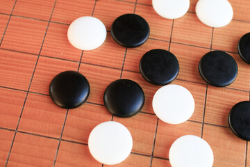 GO Japanese traditional game playing black and white stone pieces on wooden grid board. Strategy and concentrate game  