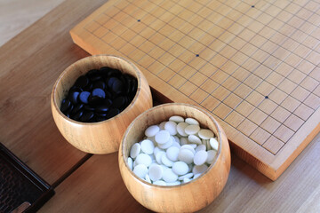 GO Japanese traditional game playing black and white stone pieces on wooden grid board. Strategy and concentrate game  
