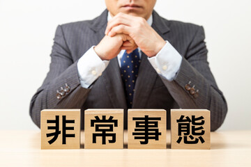 「非常事態」と書かれたブロックとビジネスマン