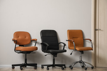 Office leather chairs near white wall in room