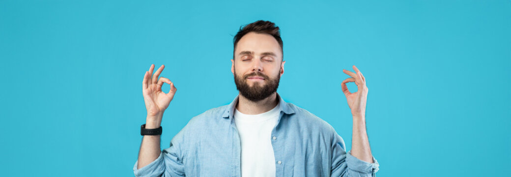 A man is meditating with a serene expression, eyes closed and fingers forming a mudra. He wears a casual shirt, creating a calm and harmonious vibe against a bright blue background. - Powered by Adobe