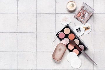 Composition with cotton pads, buds, makeup remover and cosmetic products on white tile background