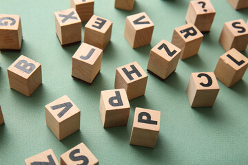 Fototapeta premium Wooden cubes with English letters on green background