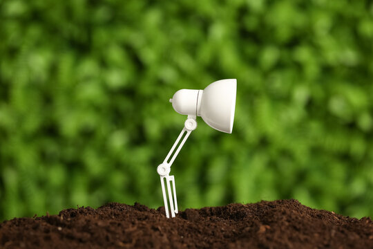 Lamp on soil outdoors. Green technology concept - Powered by Adobe