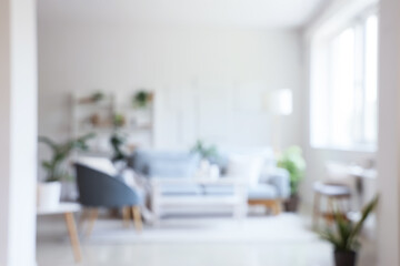 Blurred view of living room with sofa, floor lamp and armchair