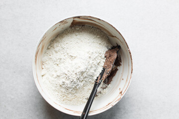 Overhead view of chocolate cookie dough being mixed in a white mixing bowl, process of making dark chocolate sugar cookies