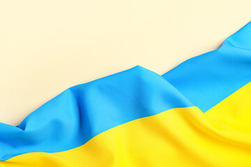 Flag of Ukraine on pale orange background, top view