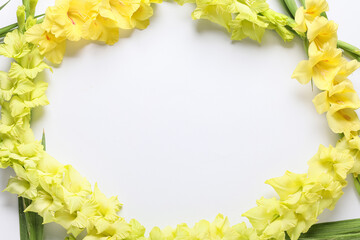 Frame made of beautiful yellow gladiolus flowers on grey background