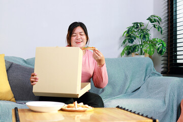 Fat woman is eating pizza. She looks happy. Weight loss concept. Health care.
