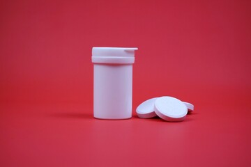 White Pill Bottle With Tablets On Red Surface, Medical, Health Care, and Pharmacy Visual