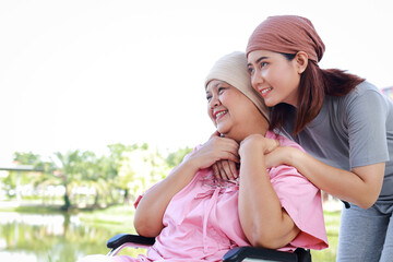 Portrait of Asian mother and daughter. Elderly mother with cancer wearing headscarf after chemo. Daughter wearing head scarf to keep her mother company. Family concept. Elderly care. copy space