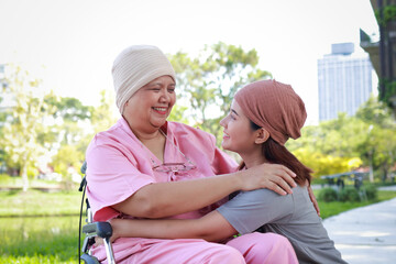 Elderly mother with cancer wears a headscarf after chemotherapy. Daughter wears a headscarf to keep her mother company. Family concept. Elderly care.