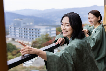 Naklejka premium 女子旅 温泉旅館 屋外の景色を眺める女性