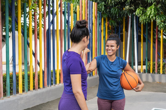 Women friends enjoying active outdoor basketball training