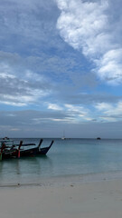 tropical beach with boats and clouds