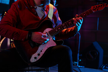 Obraz premium Man playing electric guitar on stage, closeup