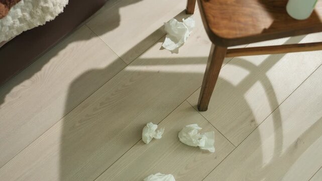 tissues near chair in sunlight, warm morning scene with blanket and cup on sideboard, soft sunbeam and curved shadowplay across wooden floor, quiet recovery and cozy wellness mood, intimate interior