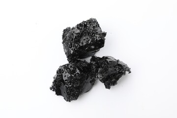 Pieces of black coal on white background, top view
