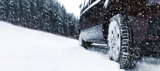 Car on snowy country road, closeup. Adverse weather conditions
