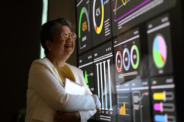 Diverse Team Working Together in Modern Co-Working Space. Casual meeting of senior diverse business team analyzing financial data. Multiethnic business people working in the office. senior woman.