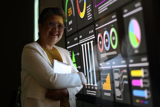 Diverse Team Working Together in Modern Co-Working Space. Casual meeting of senior diverse business team analyzing financial data. Multiethnic business people working in the office. senior woman.