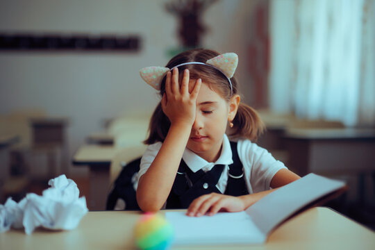 Frustrated Student Making a Mistake and a Face Palm Gesture. Unhappy little girl forgetting something while doing her assignment 
